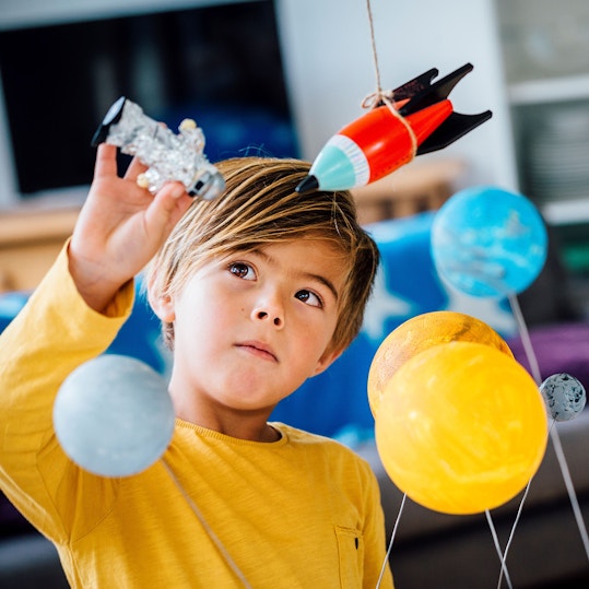A young child playing with his toy astronaut