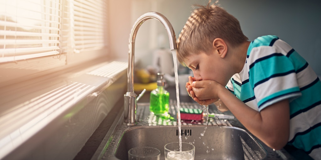 Little boy drinking tap water