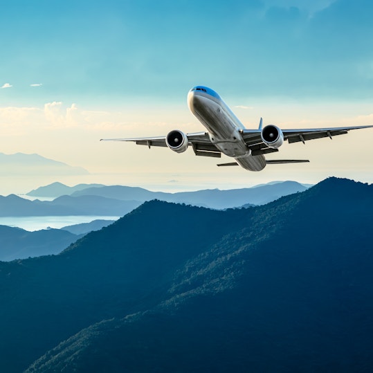 Plane takes off over green hillside