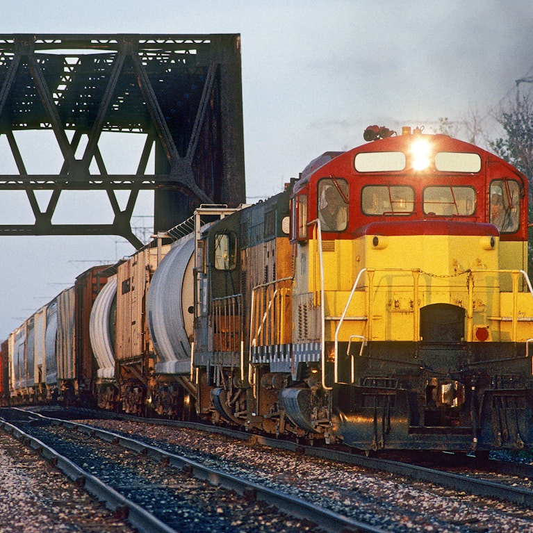 A freight train heads west through a truss bridge at 60th Street in Milwaukee, Wisconsin.