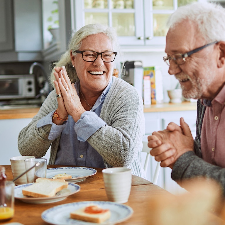 Two senior citizens having breakfast together