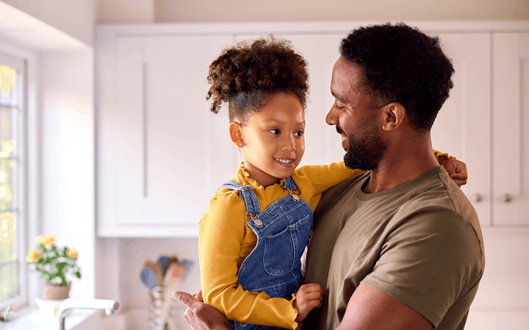 Parent smiling and holding young child