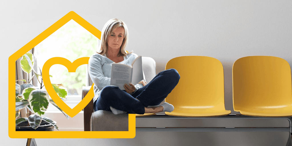 Woman seated on row of chairs reading document